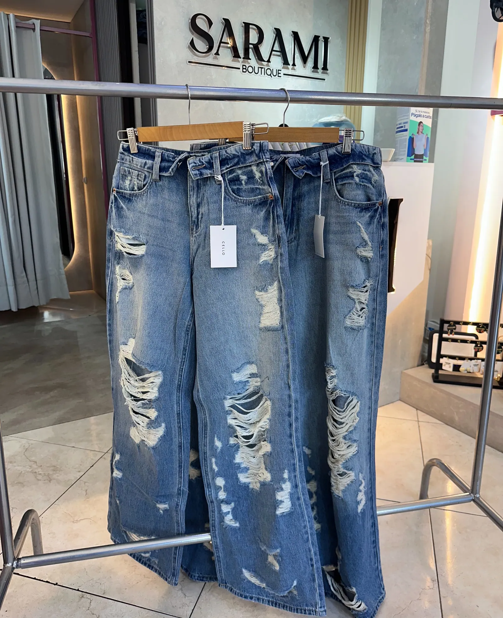 Jeans colgados frente al logo de SARAMI